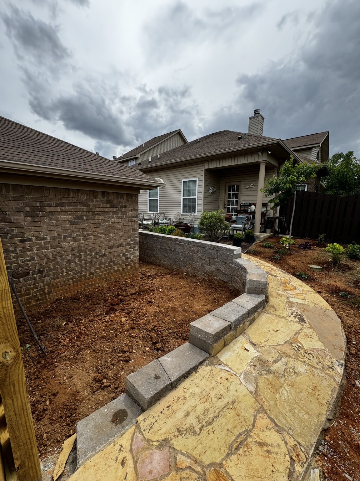 New stone path and retaining walls with courtyard planting beds prepared for installation